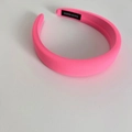 Detail of neon pink fabric headband featuring thick padded design and handmade label - Barbie Pink