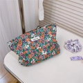 Detail of floral canvas makeup bag with orange and purple flowers and simple wish label - Green Purple Floral