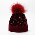 Detail of burgundy sequin knitted beanie featuring a large fluffy faux fur pom-pom topper - One Size / Wine Red (Dyed Pom Pom)
