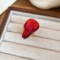 Détail d'une bague dorée avec pierre ovale en résine rouge foncé sur fond de style vintage - Bague (Rouge)