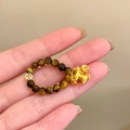 Detailopname van de tijgeroog kralenring met een gouden paard en munt bedeltje - Goud Bruin Paard Stijl