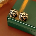 Square leopard print stud earrings displayed on a green leather jewelry gift box - Gold
