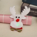 Détail d'une broche de Noël renne en peluche lumineuse avec nez rouge et écharpe rayée - Style de Renne Lumineux