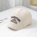 Close-up of beige kids beret cap featuring intricate black and brown letter embroidery - 50cm (1-2 Years) / Off White