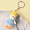 Portachiavi anatra cartone animato con cappello giallo e salopette blu su un piatto - Anatra in Abito Blu
