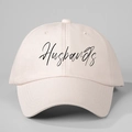 Detail view of the Husbands handwritten script print on a light pink cotton baseball cap - One Size / Beige