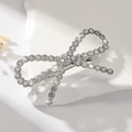 Elegant silver bow hair clip with rhinestones and pearls on a white rock base - Rhinestone Silver
