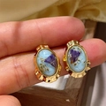 Macro shot of French vintage gold-plated earrings with colorful dried flowers in resin - Sea Blue Dried Flower