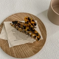 Pinza de pelo grande con estampado de leopardo ámbar sobre un fondo de lino rústico - Estampado de Leopardo Oscuro