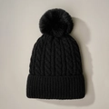 Detalle del gorro negro de punto de ochos con pompón de pelo sintético y borde acanalado - Negro