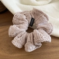 Close-up of pink knit scrunchie with hollow weave texture and fashion label on wood - Off White