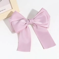 Detail of a soft pink satin bow hair clip featuring a smooth glossy silk texture - Pink