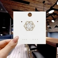 Close-up of a white and gold snowflake enamel brooch displayed on a branded card - 80*Gold Snowflake Pin