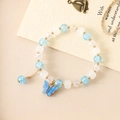 Elegant beaded bracelet featuring a blue butterfly charm and cracked ice texture beads - Blue Crackle + White Bodhi Blue Butterfly (K3515)