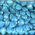 Pile of heart-shaped blue turquoise stones with black veined patterns and glossy finish - Blue Howlite