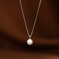 Collana a catena d'argento con un ciondolo di perla bianca su sfondo di raso - Argento