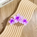 Lila Farbverlauf Haarklammer mit drei Harzblüten auf einem Holzständer präsentiert - Dreifache fünfblättrige Blüten / Lila