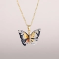 Detailed close-up of a golden butterfly pendant with black and white ink texture and zircons - Gold Chain-Ink Phantom