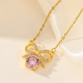 Vue macro d'un pendentif nœud doré avec pierre rose et petits diamants blancs - Nœud en Strass Rose (F209)