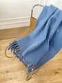 Thick mohair scarf in light blue with fringe detail on a vintage chair - Haze Blue