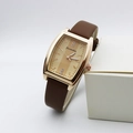 Detail of rose gold tonneau watch case with champagne striped dial and leather strap - Coffee