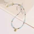 Collana di perline azzurre sfaccettate con un ciondolo rettangolare in finitura oro - Stile Acquamarina