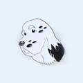 Detailed close-up of a surrealist enamel puppy dog brooch with multiple black eyes - 17-Surreal Multi-eyed White Dog