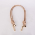 Detail of beige woven leather bag strap with knot design and gold metal clasps - Khaki