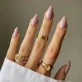Three gold rings including Roman numerals and coin signet style on pink manicured hand - Light Pink (JP2139)