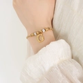 Franse stijl gouden armband met strass letter G hanger gedragen op een elegante pols - Gouden Armband - Letter G