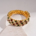 Dettaglio di un bracciale dorato a tre strati con strass rossi, verdi e trasparenti - Bracciale - Boho Colorato