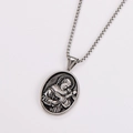 Macro view of silver oval religious pendant with embossed figure holding a cross - Antique Silver (With Chain)