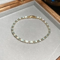 Macro detail of gold-plated bracelet with rectangular aqua blue zircons in a jewelry box - Gold-Blue