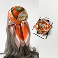 Orangefarbenes Satin-Halstuch mit Blumenmuster und braunem Rand an Model und Geschenkbox - L7210-Gardenie Orange