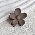Macro detail of a matte coffee brown flower hair claw clip with a frosted resin texture - Brown