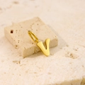Polished golden stainless steel letter V pendant necklace displayed on a textured stone - Letter-V / Gold