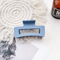 Detailed view of a medium blue matte rectangular hair claw clip on a woven coaster - Medium Matte Square Claw-Denim Blue