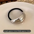 Elastic hair tie with a 5.5cm silver curved metal piece on a white ceramic plate - Large Oval Silver