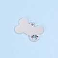 Close-up of a silver bone-shaped dog tag with a hollow paw print and polished finish - Large (24*36mm) / Steel