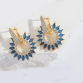 Macro view of gold sunburst earring with marquise blue zircon and white diamonds - Pentagram