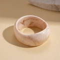 Detail shot of thick resin bangle featuring pink marble texture and smooth finish - Beige-Irregular