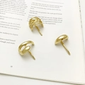 Three-piece minimalist gold-plated hoop earring set on an open book background - Hollow Three-Piece Set / Gold