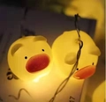 Close-up of adorable pig-shaped LED string lights emitting a warm yellow festive glow - Warm White Pig (1.8m 10 LEDs - 2AA Constant Light Battery Box)