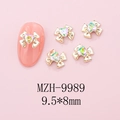 Detailed macro of 9.5x8mm bow nail art charms with heart crystal on pink nails - Gold Bow + Pink Green Heart Stone (9989)