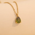 Golden necklace featuring a vibrant green teardrop gemstone pendant on a fine chain - February (Green)