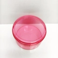 Pink transparent round plastic storage container with a screw cap on white background - Round / Red