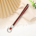 Détail du bracelet tressé rouge, blanc et noir avec un fermoir anneau doré en métal - Largeur 12mm / Rouge Blanc