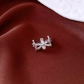 Detailweergave van zilveren ring met witte zirkoon op donkerrode zijde achtergrond - Enkele oormanchet / Zilver