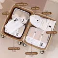 8-piece white travel storage bag set with black text neatly organized in a suitcase - White 9-Piece Set