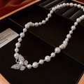Dettaglio di elegante collana di perle con chiusura a farfalla in una scatola nera - Collana di Perle Bianche con Chiusura a Farfalla con Strass (Stile 33)